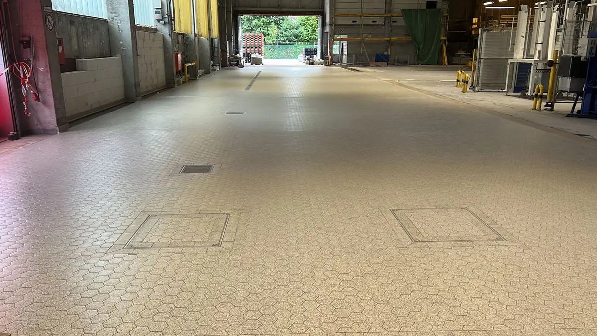 Podea industrială din plăci ceramice echipată cu canale de scurgere, sifoane de pardoseală și capace de revizie